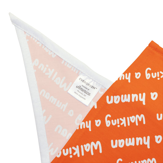 orange "walking a human" repeating text bandana on a dog